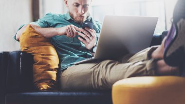 Sakallı Hipster çalışma Laptop modern Tasarım İç Studio Loft.Men çalışma Vintage Kanepe, Çağdaş Notebook kullanın, Smartphone.Blurred Background.Creative Business Startup Idea.Horizontal, Film