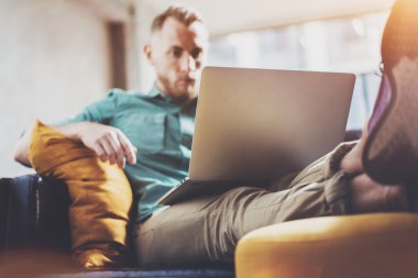Sakallı Hipster çalışma Laptop modern İç Tasarım Loft Office.Men vintage kanepe iş, çağdaş Notebook kullanın, klavye yazarak. Bulanık Arka Plan.Yaratıcı İş Başlangıç Idea.Horizontal, Film effe