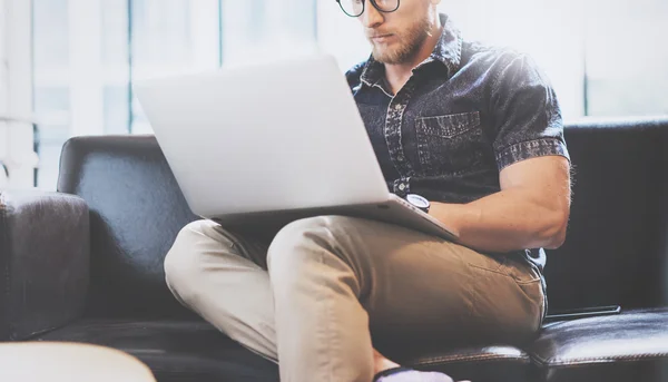 Exitoso Gerente de Comercio de trabajo portátil moderno Diseño de interiores Loft Office.Men trabajo Vintage Sofá, Utilice el cuaderno contemporáneo, Internet de la navegación. fondo borroso. — Foto de Stock