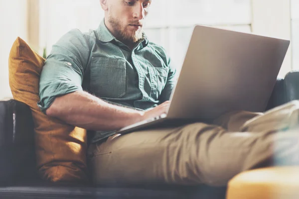 Bearded Hipster working Laptop modern Interior Design Loft Office.Man work Vintage Sofa,Use contemporary Notebook,Browsing Internet.Blurred Background.Business Startup Idea Process.Horizontal,Film. — Stock Photo, Image