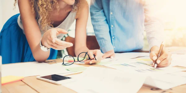 Medarbetare lagarbete bearbetar modernt kontors Loft. Kontoansvariga producerar kreativt idéprojekt. Young Business Crew arbetar startup. smartphone träbord. analysera marknadsrapporter. suddig, film flare effekt — Stockfoto