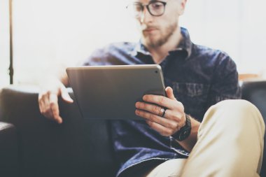 Sakallı pazarlama uzmanı çalışma dijital tablet modern İç Tasarım Loft Office.Man klasik kanepe kullanımı çağdaş cihaz Hand.Blurred Arka Plan Yeni yaratıcı Süreç İş Başlangıç Fikir dinlenmek