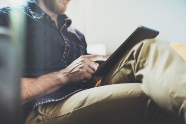 Banka hesap yöneticisi okuma iş haberleri modern İç Tasarım Loft Office.Man vintage kanepe dinlenmek, Çağdaş tablet kullanın, bilgi paylaşmak. Bulanık Arka Plan.Yeni Başlangıç Fikri Süreci Closeup