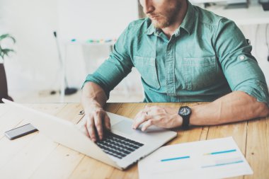 Bölüm ekonomist ahşap masa dizüstü Modern İç Tasarım Loft Place.Businessman İş Coworking Studio.Man Kullanım çağdaş Notebook, klavye yazarak çalışma. Bulanık Arka Plan. İş Başlangıç.