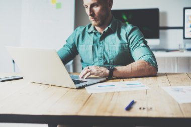 Online Market Ekonomist Çalışma Ahşap Masa Laptop Modern İç Tasarım Loft Place.Businessman İş Coworking Studio.Men kullanın çağdaş Notebook klavye yazarak. Bulanık Arka Plan. İş Başlangıç