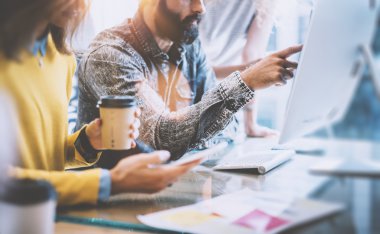 Business Startup Concept.Coworkers Teamworking Process.Bearded Hipster Gösteren El Ekranı Bilgisayar.Akıllı Telefon Kullanan Genç Kadın.Yaratıcı İnsanlar İş Yeni Proje Ahşap Masa Masa.Bulanık Fişekler Etkisi.