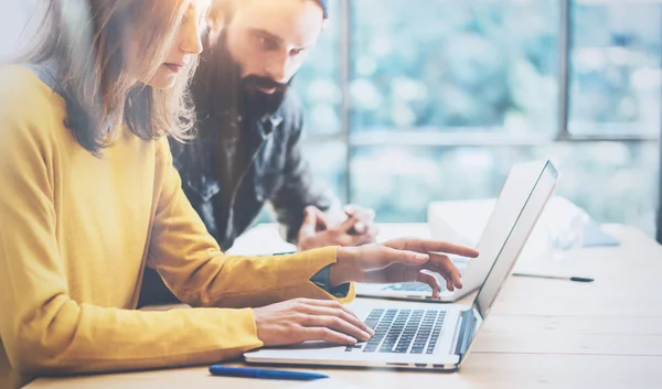 Nahaufnahme zwei moderne Mitarbeiter diskutieren gemeinsam während des Arbeitsprozesses. Junge Geschäftsleute treffen sich konzept.Diskussion Startup-Projekt office.hipsters work laptop wood desk table.unscharf. — Stockfoto