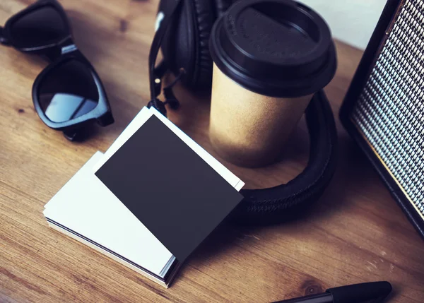 Close-up stack leeg papier visitekaartje mockup hout tabel. Kraft take away koffie kopje Coworking Studio. moderne koptelefoon draagbare speaker zonnebril Bureau achtergrond. Lifestyle mock up voorwerpen. — Stockfoto