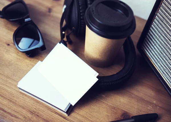 Closeup stack névjegykártya fehér könyv. Blank mintadarab fa Desk háttér. take away kávéscsésze coworking. modern fejhallgató hordozható hangszóró napszemüveg Interior Cafe. életmód modell up objektumok. — Stock Fotó