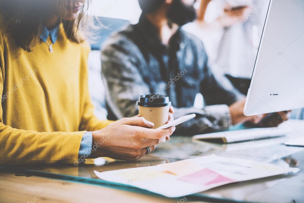 Business Startup Concept.Coworkers Meeting During Work Process.Bearded Hipster Making Great Decisions.Young Woman Using Smartphone Hand.People Working New Project Wood Desk Table.Blurred.