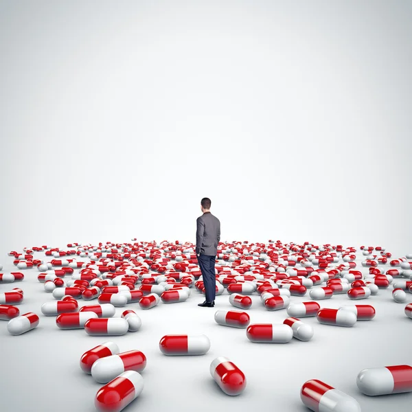 Man standing among medical pills — Stock Photo, Image