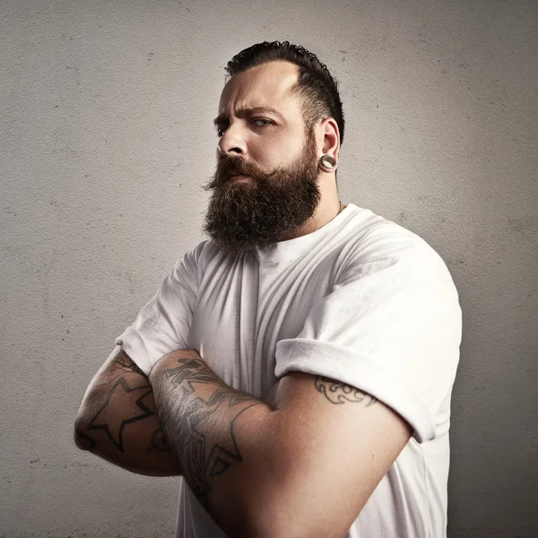 Татуированный бородатый мужчина в футболке — стоковое фото