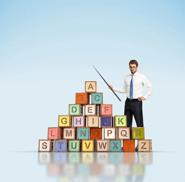 Lehrer und bunte Buchstabenblöcke — Stockfoto