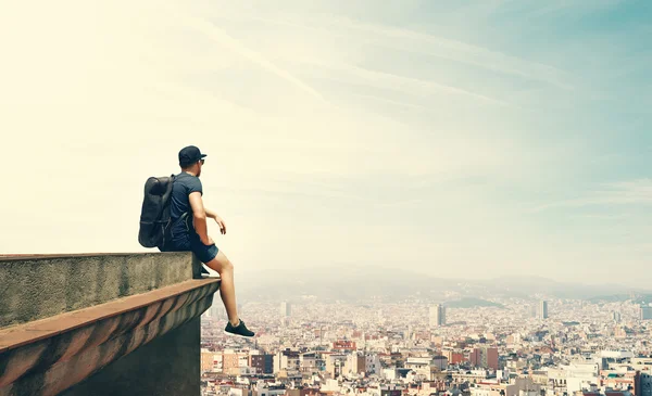 Young man is sitting on a roof — Stock Photo, Image