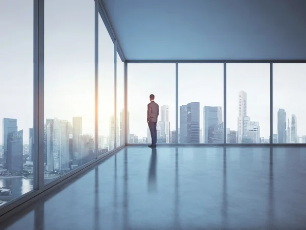 Zakenman in office en kijken naar stad — Stockfoto