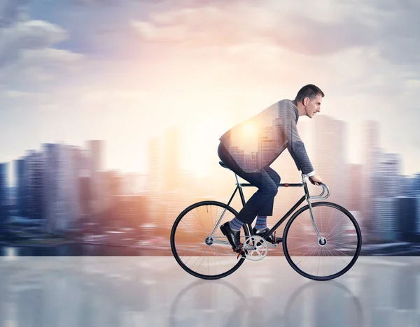 Homem em uma bicicleta e cidade — Fotografia de Stock