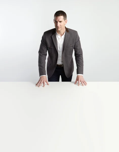 Деловой человек стоит за столом — стоковое фото