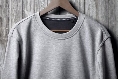 gri jumper ahşap duvarda asılı