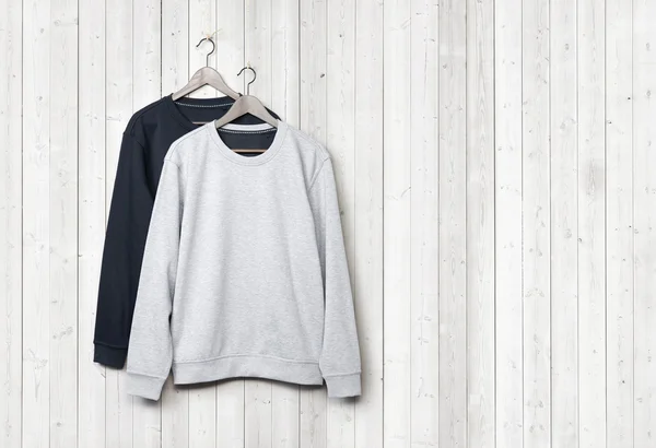 Sweaters on wood wall — Stock Photo, Image