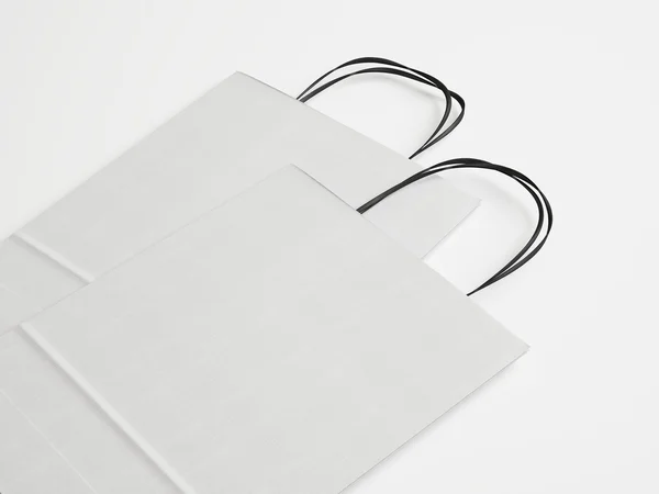 İki beyaz kağıt çanta siyah kulplu — Stok fotoğraf