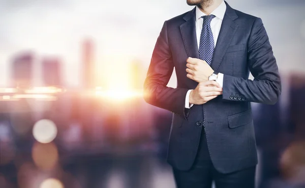 Businessman on blurred city background — Stock Photo, Image