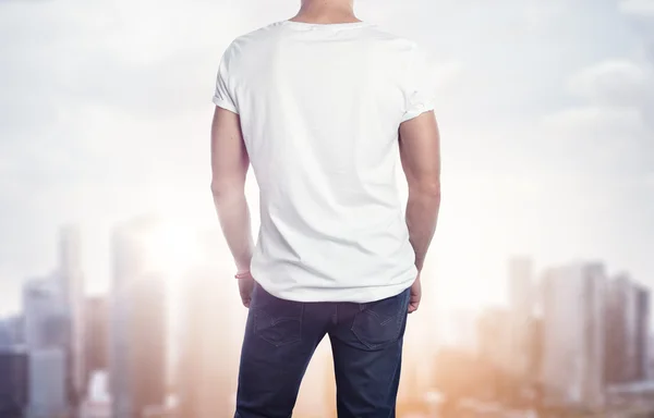Man in white t-shirt over city — Stock Photo, Image