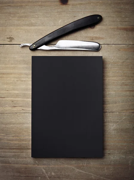 Straight razor and black paper — Stock Photo, Image