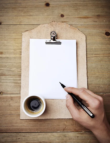 Hand with pen over clipboard — Stock Photo, Image