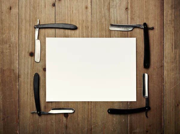 Straight of vintage razors and white picture frame on wood desk — Stock Photo, Image