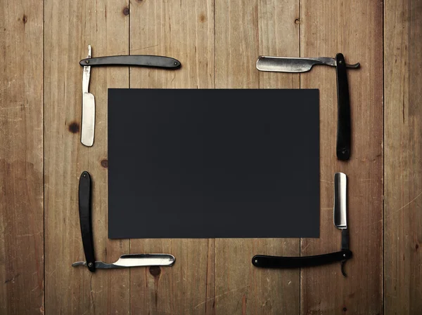 Straight of vintage razors and black picture frame on wood desk — Stock Photo, Image