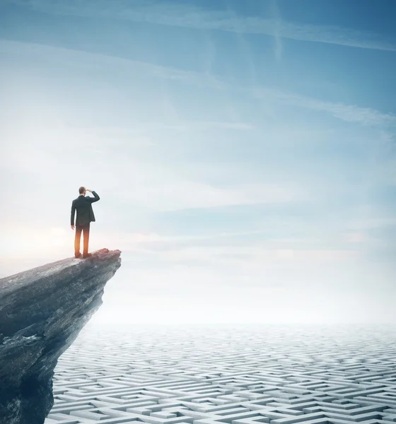 Homme d'affaires debout sur un rocher et regardant un énorme labyrinthe. Rendu 3d — Photo