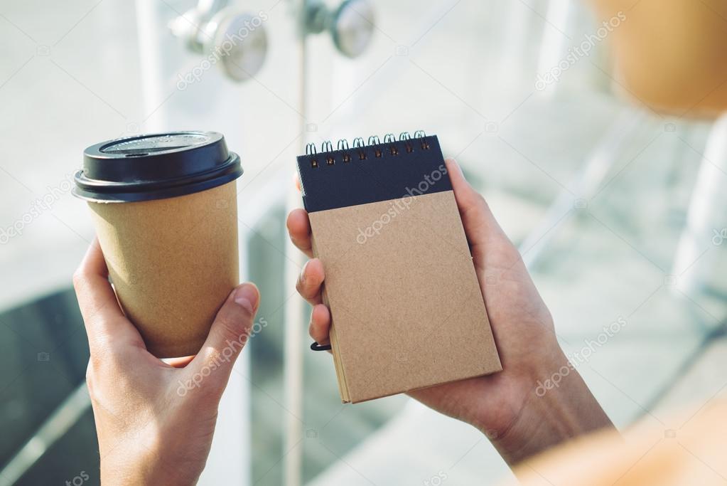 cup of coffee and note book in hands