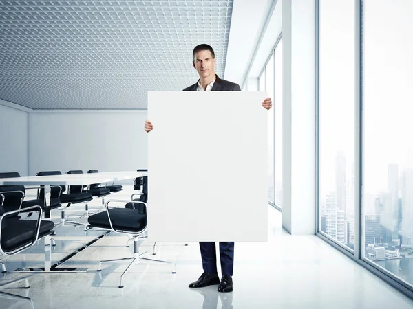 Geschäftsmann hält Leinwand in modernem Büro — Stockfoto