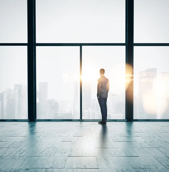 Geschäftsmann schaut Sonnenaufgang auf dem Dachboden an — Stockfoto