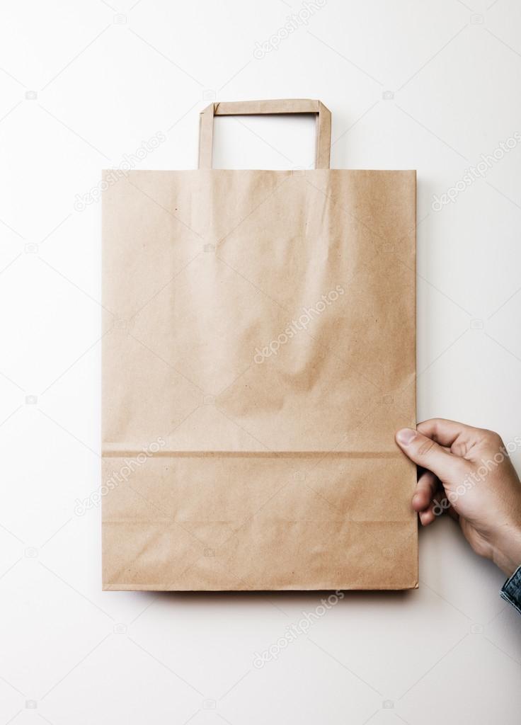 Mock up of paper bag holding in a hand