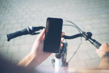 Şehirde seyahat için Smartphone ve bisiklet kullanan kız