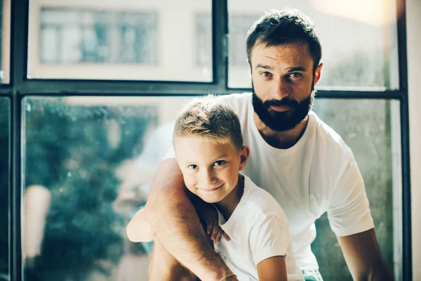 Ritratto di un uomo barbuto e suo figlio vicino alla finestra — Foto Stock