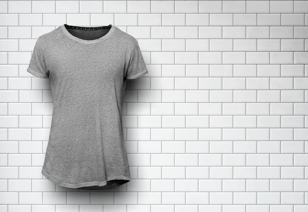 Tshirt grigia isolata e parete dello sfondo mattoni — Foto Stock