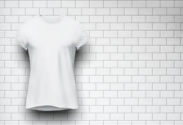 White tshirt isolated on the wall of bricks background — Stock Photo, Image