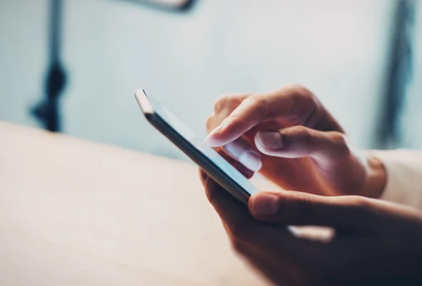 Chica usando su teléfono inteligente en un café. Efecto desenfoque — Foto de Stock