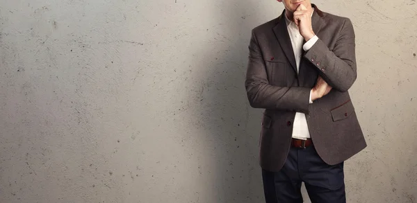 Jeune homme d'affaires sur le fond d'un mur de béton — Photo