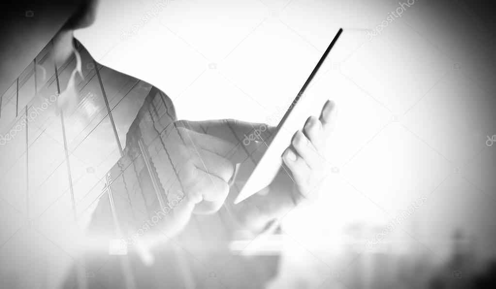 Double exposure of city and man using digital tablet