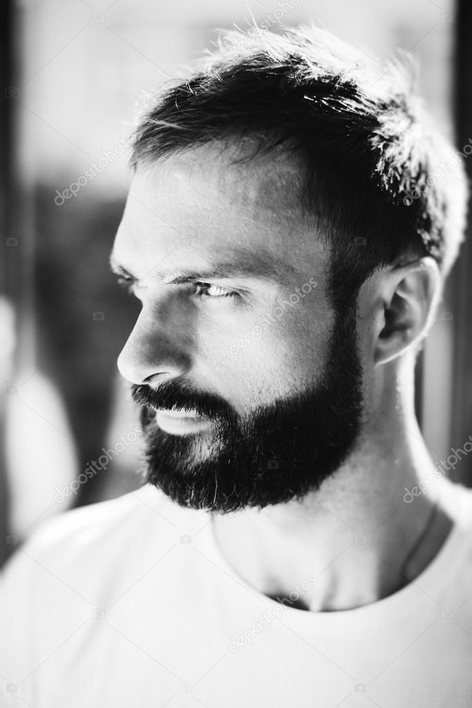 BW picture of a bearded man wearing white tshirt on the blure background