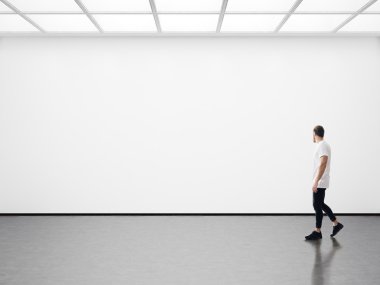 Boş galeride yürüyen genç adam