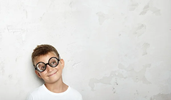 Menino sorrindo no fundo da parede branca — Fotografia de Stock