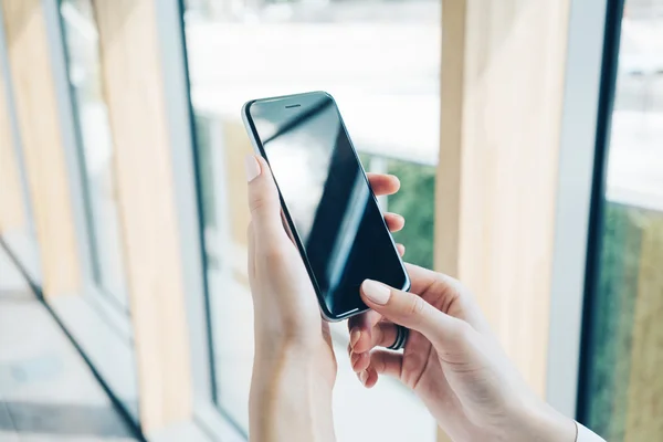 Chica sosteniendo el teléfono inteligente en unas manos —  Fotos de Stock