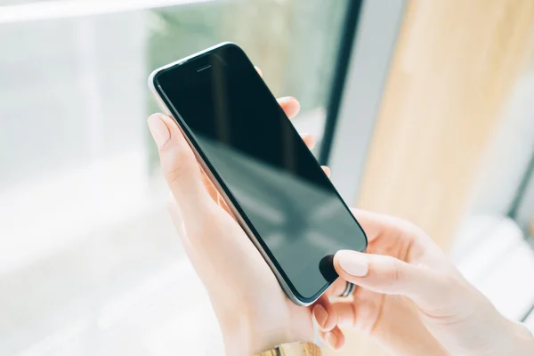 Smartphone em branco segurando em mãos femininas — Fotografia de Stock