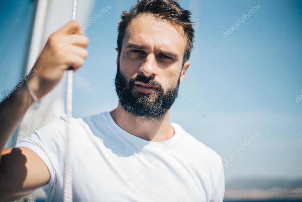 bearded man wering white t-shirt.