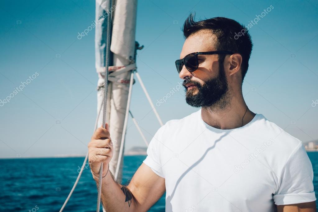 uomo barbuto in piedi su uno yacht