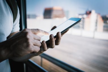 Blank smartphone holding in male hand, he wearing a white shirt